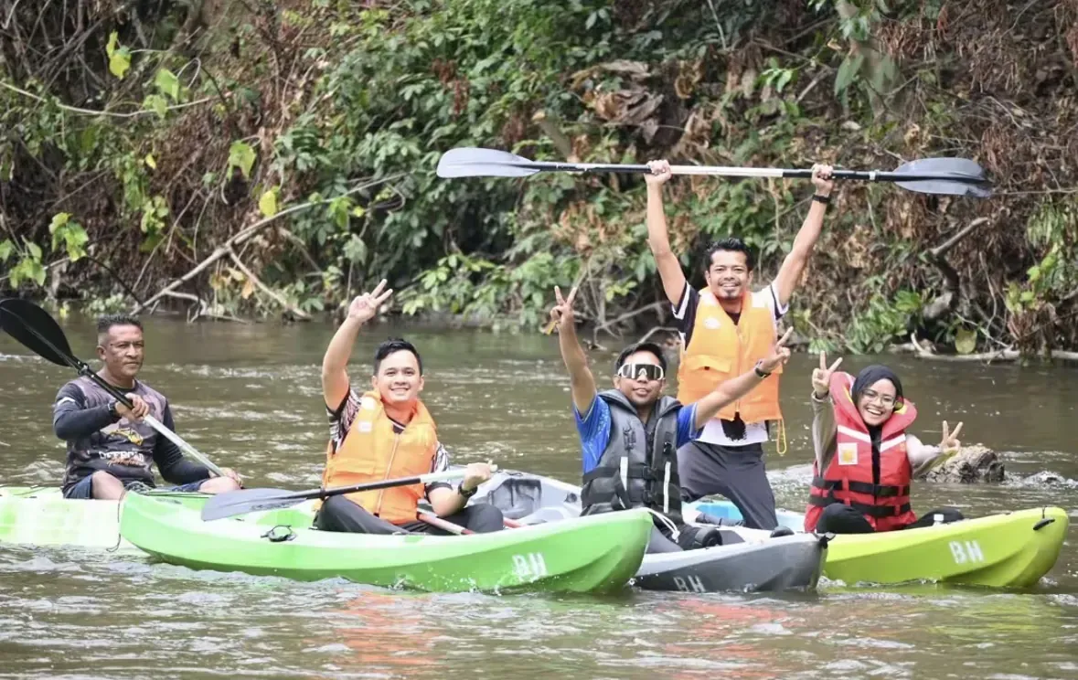 Geng berkayak di sungai sambil angkat dayung